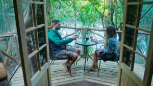 Couple having wine on balcony in rio suite at Pucon Kayak Retreat