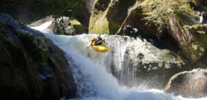 Kayaking during Pucon Creek Week with a Waterfall Boof